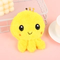 Macro detail of cute yellow plush octopus coin purse with embroidery on pink background - Yellow