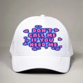 White trucker hat with pink bubble text slogan and heart detail on a plain background - One Size / All White