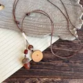 Detailed shot of ethnic necklace featuring acorn pendant and wooden beads on wax cord - Brown Acorn Wood Chip Style (HN7421)