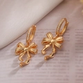 Exquisite gold-plated bow earrings with inlaid zircons shown in a detailed close-up shot - Delicate Bowknot Ear Buckle / Gold