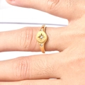 Detailed view of an 18K gold star ring set with three clear zircons on a finger - US 6 / Gold