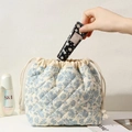 Close-up of quilted floral drawstring bag with soft padding and cotton cord detail - Orchid