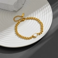 Pulsera dorada de espiga con dije de corazón blanco sobre una bandeja de cerámica - Estilo de Corazón (M804)