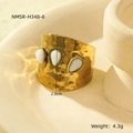 Macro view of wide gold ring with pleated texture and three white teardrop stones - White