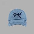 Detail of light blue denim baseball cap featuring dark blue bow embroidery and texture - Denim Bow Baseball Cap Style / Medium Blue & White