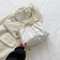 Elegante borsa a nuvola bianca con manico di perle e tracolla sopra un blazer beige - Bianco
