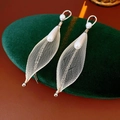 Dettaglio macro di orecchini a foglia in maglia dorata con perle su velluto verde - Perno in Argento S925 / Argento