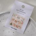 Dettaglio di adesivi nail art natalizi con strass K9 e motivi di alberi festivi in 3D - MJ-008 Stampaggio in Oro
