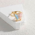 Detalle macro de un anillo ajustable de oro 18k con mariposa brillante en azul y rosa - Mariposa Degradada (R782-hudie)