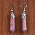 Dettaglio macro di orecchini di cristallo rosa esagonale con motivi a onde d'argento - Rodonite