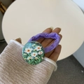 Detalle de coletero morado con margarita pintada a mano en la muñeca del modelo - Margarita Pequeña