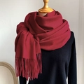 Classic vibrant red cashmere-like scarf with fringe tassels on a black knit sweater - Burgundy