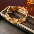 Bracciale largo dorato con maglie ondulate irregolari in un portagioie nero - Oro