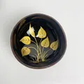 Polished coconut shell bowl with deep black finish and golden leaf pattern design - Yellow Leaf Style