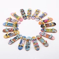 Top view of a diverse collection of mini alloy finger skateboards with colorful graffiti art - Single Skateboard Loose