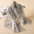 Elegant leopard print chiffon scarf in beige and brown hanging on a wooden hanger - Beige Brown Leopard
