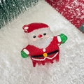 Close-up of a Santa Claus hair claw clip with glitter finish on festive Christmas decor - Santa Claus