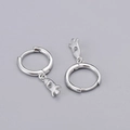 Macro detail of silver S925 sterling silver hoop earrings with hollow rocket pendants - Rocket Earrings - Silver