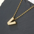 Gold plated initial V necklace with sparkling cubic zirconia on a grey slate background - Letter V (Pendant Only)