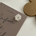 Elegante pinza per capelli a forma di conchiglia bianca su un libro in stile vintage - Mini Pinza Rotonda