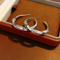 Detalle macro de pendientes en C de plata trenzada con circón blanco en caja de joyas - Poste de Pendiente de Plata de Ley 925 - Bañado en Oro / Plata - Grande