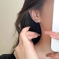 Chic silver heart intertwined stud earrings shown on a model for a stylish look - Silver Crossed Heart Stud Earrings