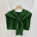 Green knitted cross-wrap shawl scarf displayed on a wooden hanger against a white wall - Dark Green