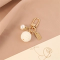 Close-up of gold alloy keychain with hollow heart pearls and Sweet Rose engraved tag - Pearl Sphere Style (A)