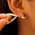Detail van vintage tijgeroog oorbellen met gehamerd gouden metalen frame op een model - Gehamerd Ovaal Stijl (11900-Legering) / Goud