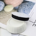 Macro view of black elastic cord spool on white ceramic base for DIY jewelry making - 10m / Black
