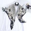 Elegant black and white floral lace print square silk scarf draped over basic white outfit - Black Floral