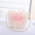 Nahaufnahme der cremefarbenen Strohtasche mit rosa Netzschleife und Perlenbesatz - Weiß mit Rosa Sternenschleife