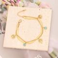Detail eines goldenen Doppelarmbands mit Baum des Lebens und Türkis auf Steinplatte - Lebensbaum und Türkis Anhänger Stil (1#)