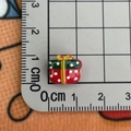 Macro view of a 1cm Christmas gift box resin charm measured on a metric scale ruler - Gift Box