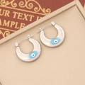 Close-up of crescent stainless steel earrings with blue evil eye enamel on beige velvet - 10# (Silver Crescent Blue Eye)