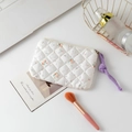 Close-up of quilted floral cosmetic bag with a purple braided rope zipper puller - White Floral