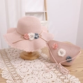 Détail d'un ensemble chapeau et sac en paille rose avec fleurs et perles décoratives - Chapeau Rose + Sac