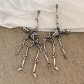 Detail shot of silver skull stud earrings on neutral textured background for gothic style - Skeleton Dangle Earrings / Silver