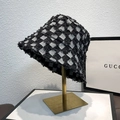 Dettaglio cappello a secchiello a scacchi con bordi sfrangiati su supporto in metallo dorato - M (56-58cm) / Nero