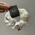 Détail du chouchou en dentelle blanche fleurie avec ruban amovible et étiquette de marque - Type standard / Chouchou à Fleurs Vertes