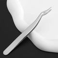 Macro shot of curved stainless steel eyelash tweezers with professional silver finish - Silver