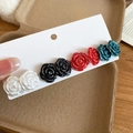 Detailed macro view of four pairs of elegant 3D rose stud earrings in various colors - 4 Pairs Set - Black/White/Red/Blue