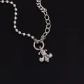 Silver dual-chain hip hop necklace with fleur-de-lis zircon pendant on black reflection - Silver
