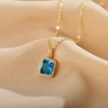 Golden titanium necklace featuring a rectangular blue gemstone pendant with zircon accents - Blue