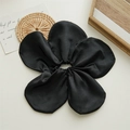 Detail of a large black flower scrunchie with satin texture on a white backdrop - Black