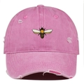 Détail de la broderie abeille et des déchirures sur la casquette de baseball rose délavée - Taille unique / Rose