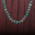 Gros plan détaillé de perles d'aventurine verte naturelle sur fond de bois rustique - Collier en aventurine verte