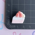 Vista dall'alto di un accessorio in resina a torta di fragole misurato su base di taglio - Torta alla Fragola Triangolare Rosa