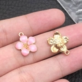 Pink enamel flower pendant with golden base and attachment ring shown on fingertips - 1Pc Pink Cherry Blossom 14x16mm