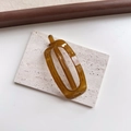 Detail of amber translucent rectangular hair clip on textured stone, minimalist resin hairpiece - Oval Tea